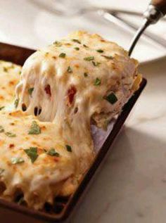 a piece of lasagna being lifted with a fork from a casserole dish