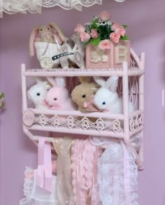 a pink shelf filled with stuffed animals next to a baby's carriage and crib