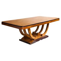 an art deco dining table with curved legs and wood grained top, on white background