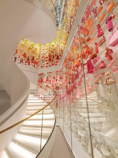 there are many shoes on display in the glass case at the bottom of the stairs