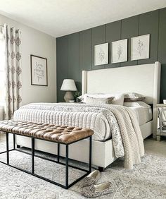 a bedroom with a large bed and two pictures on the wall above it's headboard