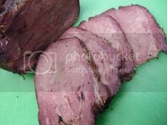 sliced meat sitting on top of a green cutting board