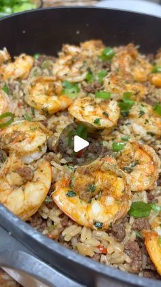 a pan filled with shrimp and rice on top of a table