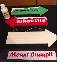 paper cut out signs on top of a table next to glue bottles and marker pens