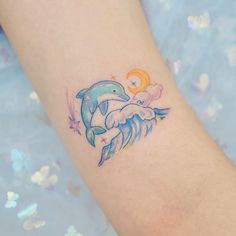 a small dolphin tattoo on the arm