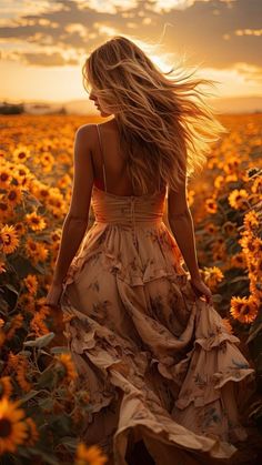 a woman in a sunflower field with her hair blowing in the wind, wearing a dress