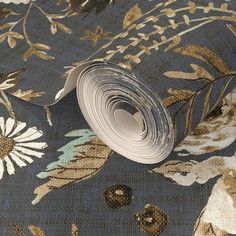 a roll of blue and gold floral wallpaper with white flowers on the bottom half of it