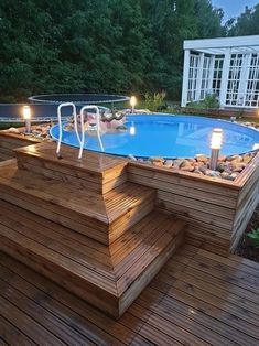 an above ground pool with steps leading up to it and lit candles on the deck