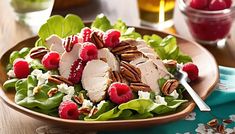 a salad with pecans, raspberries and almonds in it on a plate