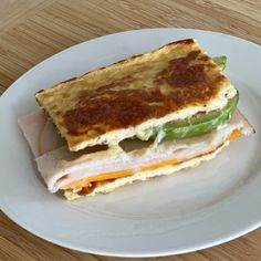 a white plate topped with a cut in half sandwich on top of a wooden table