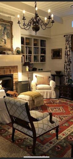 a living room filled with furniture and a chandelier hanging from the ceiling over a fire place