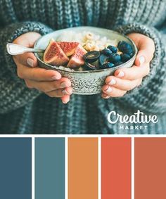 a woman holding a bowl filled with fruit and vegetables in front of a color palette