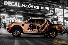 a black and white photo of a truck parked in front of a building with an elephant decal on the side