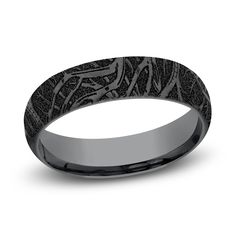 a wedding band with an intricate design in black gold, is shown on a white background