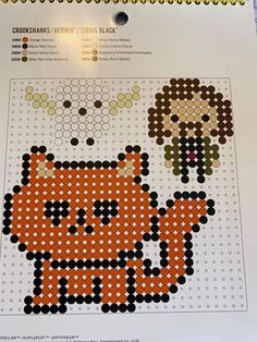 an orange and black cross stitch pattern on a sheet of paper