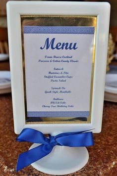 a white and gold plate with a blue ribbon around it