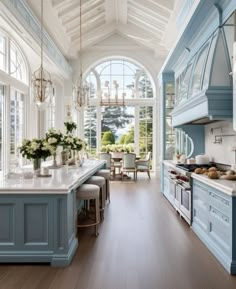 a large kitchen with blue cabinets and white counter tops, along with an island in the middle