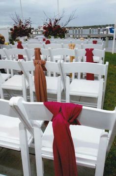 rows of white chairs with red sashes on them