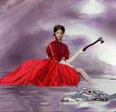 a woman in a red dress sitting on top of a alligator