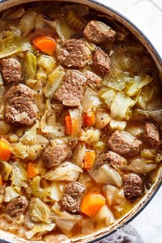 a pot filled with meat and vegetables on top of a table