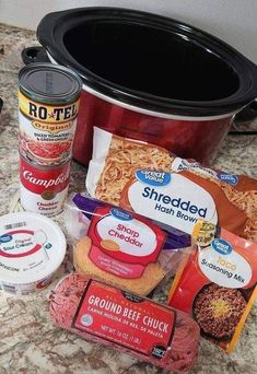 some food is sitting on the counter next to a crock pot and other items