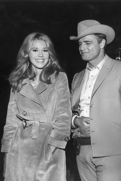 a man in a cowboy hat standing next to a woman