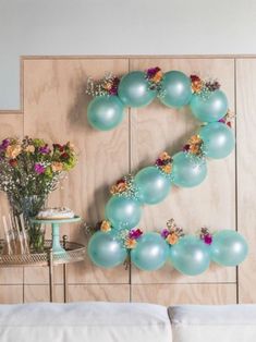 balloons are arranged in the shape of the letter e on a wall above a bed