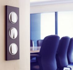 an office meeting room with chairs and a wall mounted device