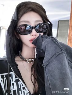 a woman wearing sunglasses and a hoodie