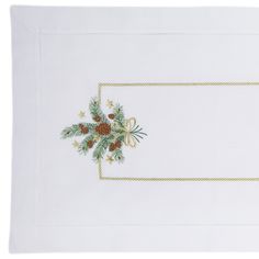 a white place mat with pine cones and bows on it, in front of a white background