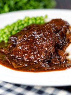 a close up of a plate of food with meat and gravy on it