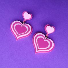 These retro inspired cuties are laser cut from pastel and dusky pink acrylic shades. The large charms measure 35mm wide and feature heart shaped pads with plated metal studs and clear hypoallergenic rubber backs. Please note, we are unable to accept returns of earrings due to hygiene laws. Be sure to check colour and sizing details before purchase. We hope you enjoy your jewellery! Wear with care :) We do not tolerate plagiarism. Anyone found selling the same designs and infringing copyright will be met with appropriate action. Playful Pink Heart Earrings For Valentine's Day, Retro Heart-shaped Earrings For Valentine's Day, Retro Heart Earrings For Valentine's Day, Cute Pink Double Heart Earrings, Trendy Pink Double Heart Earrings, Trendy Pink Heart Print Earrings, Retro Heart, Pink Acrylic, Pink Acrylics