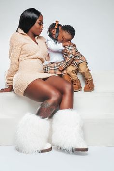 a woman sitting on top of a white bench next to a child