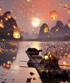 a person in a boat floating on top of water with lanterns flying over the water