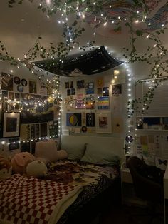 a bedroom with lights strung from the ceiling and pictures on the wall above the bed