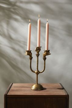 a brass candelabra with three candles on it