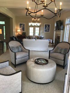 a living room filled with lots of furniture and a chandelier hanging from the ceiling