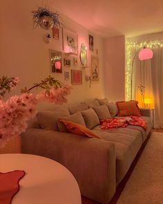 a living room filled with lots of furniture next to a wall covered in pink flowers