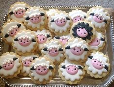 there are many decorated cookies in the shape of sheeps on this platter with pink and white frosting