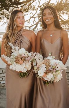 two beautiful women standing next to each other holding bouquets