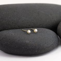 These solid 14K tiny stud pearl earrings are perfect for a tiny bit of regal glow or for second piercings. They feature genuine lovely 3mm pearls that are ringed with the thinnest thread of 14K. The post is centered on the back of the 14K gold disc and matching 14K earring backs are included. Reliable and effortless - exactly the kind of sparkle that I love to add to my day. Second Piercings, Stud Pearl Earrings, Second Hole Earrings, Solid Gold Bangle, Herkimer Diamond Earrings, Hammered Wedding Bands, Ruby Earrings Studs, Second Piercing, Gold Disc