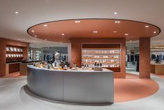 the inside of a retail store with shelves and bottles on display behind a curved counter