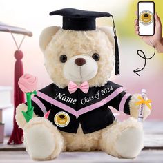 a teddy bear wearing a graduation outfit and holding a cell phone with the name class of 2013 on it