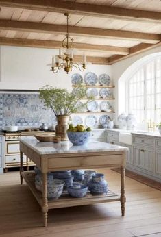 a kitchen filled with lots of blue and white dishes on top of a wooden table