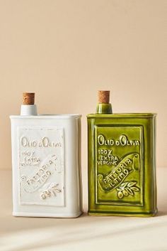 two old olive oil bottles sitting next to each other