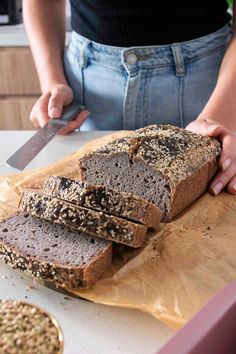 a person cutting up some bread on top of a table