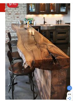 a wooden counter top sitting in the middle of a kitchen next to two bar stools