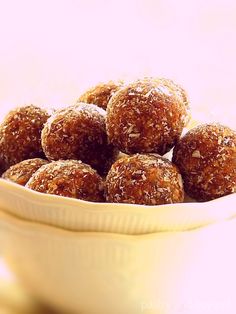 a white bowl filled with sugar covered donuts