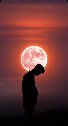 the silhouette of a man standing in front of a full moon at sunset or sunrise