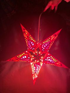 a red light that is on top of a paper origami star shaped object